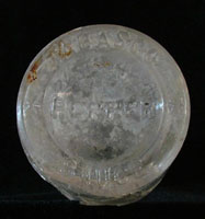 Figure9. The rare Tabasco bottle recovered during archaeological excavations of the Boston Saloon is shown here, with acloseupviewof thebasemark. Photos by RonaldM. James.